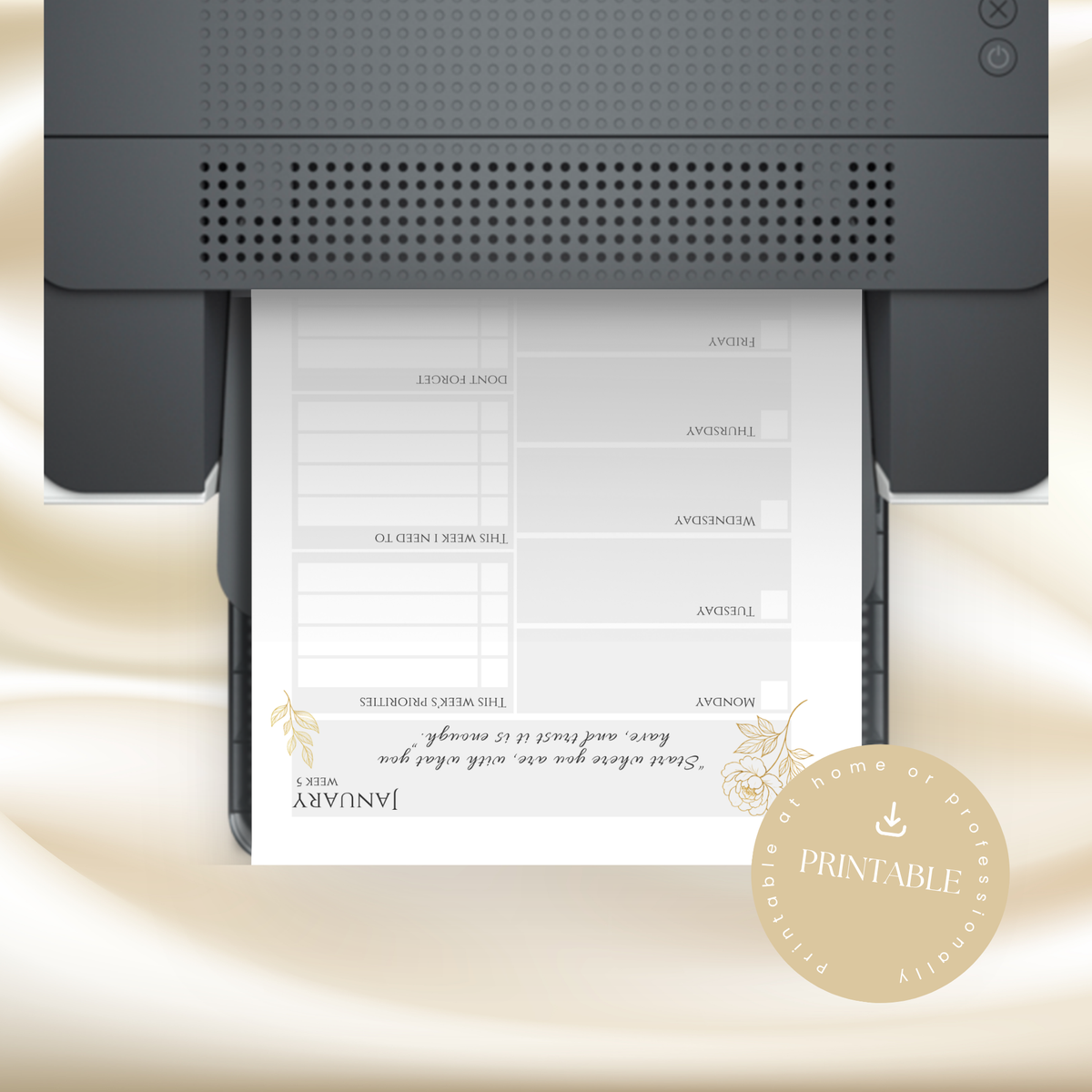 A printable weekly planner page shown emerging from a printer, with a beige satin-like background and a circular badge reading 'Printable' in the lower right corner.