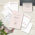 A styled flat-lay of a journaling set on a light stone surface, including a blush pink journal cover titled 'Self Love,' several lined journal pages, a printable planner insert, and decorative flowers. No person, animal, or real environment beyond the tabletop styling is present, so this is Product/Packaging rather than Lifestyle.
