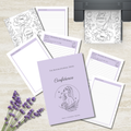 A flat-lay of a journaling and affirmation kit featuring a lavender hardcover journal titled 'Confidence' and several matching lined notepads and printable pages with floral line art and lavender accents, arranged on a light wood surface with lavender sprigs and a printer visible in the background.